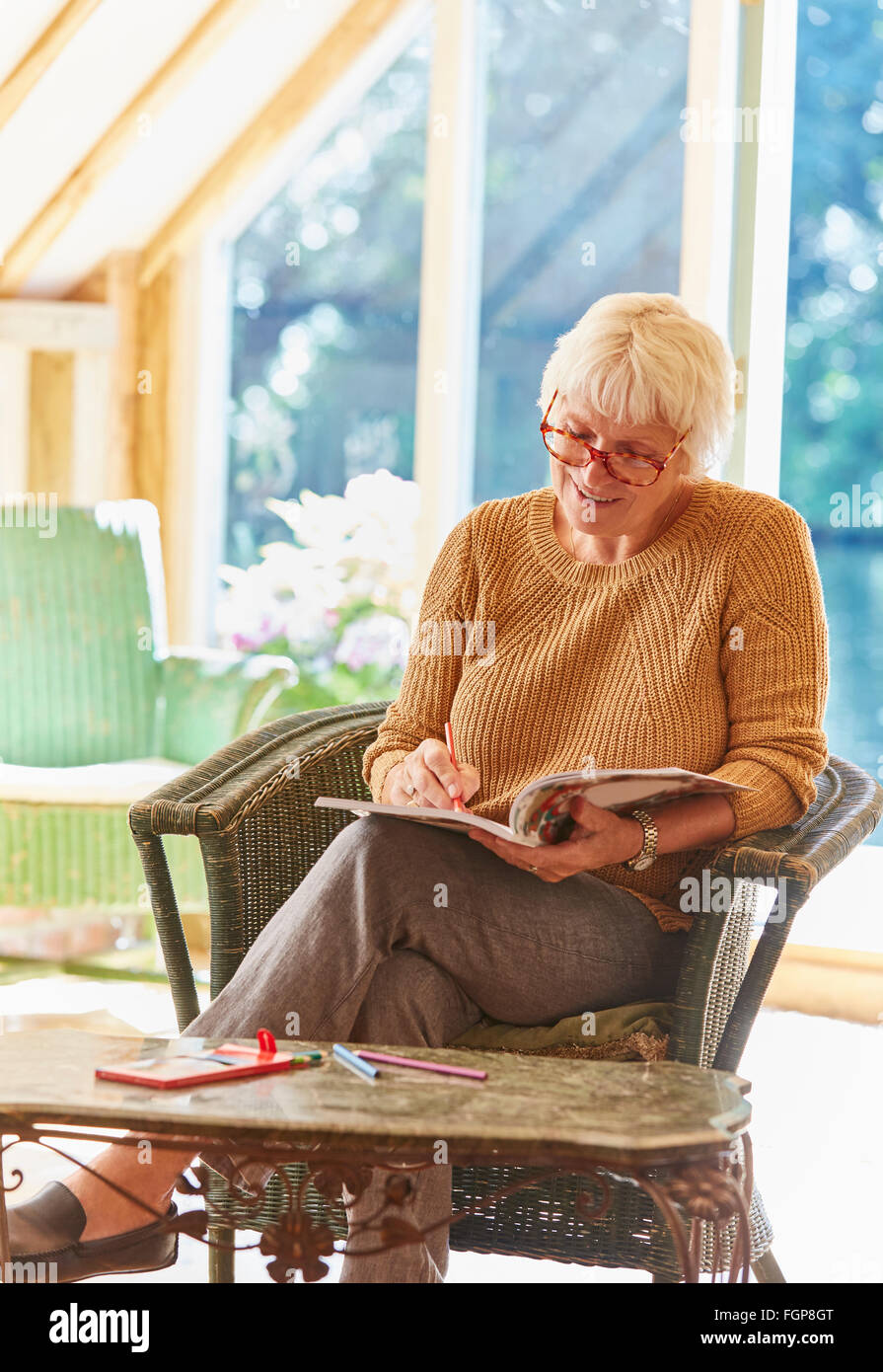 Femme senior dans un livre à colorier coloriage Banque D'Images