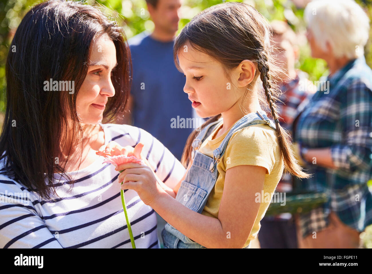 Mother holding daughter with flower Banque D'Images