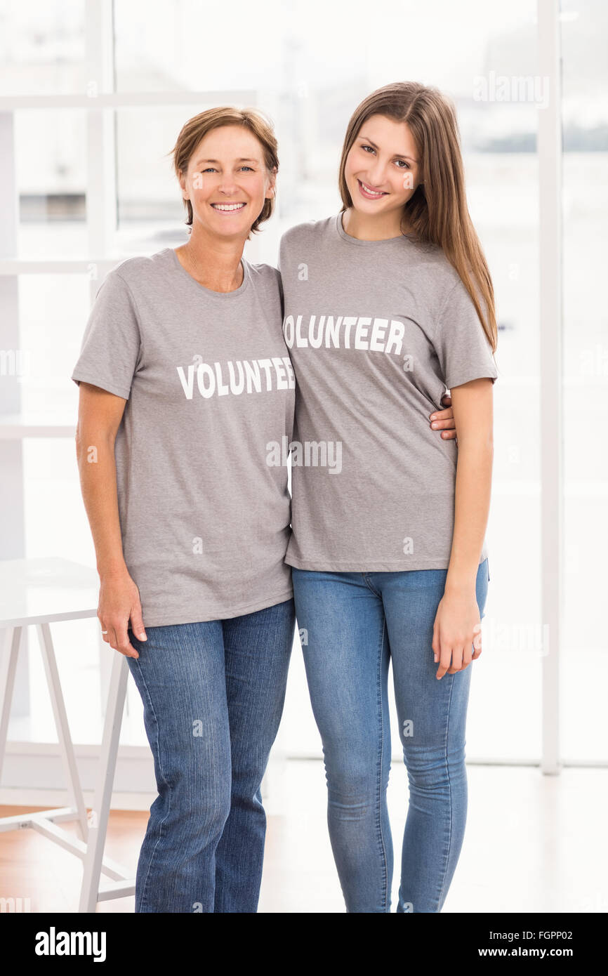 Des femmes volontaires souriants bras mettre autour de l'autre Banque D'Images