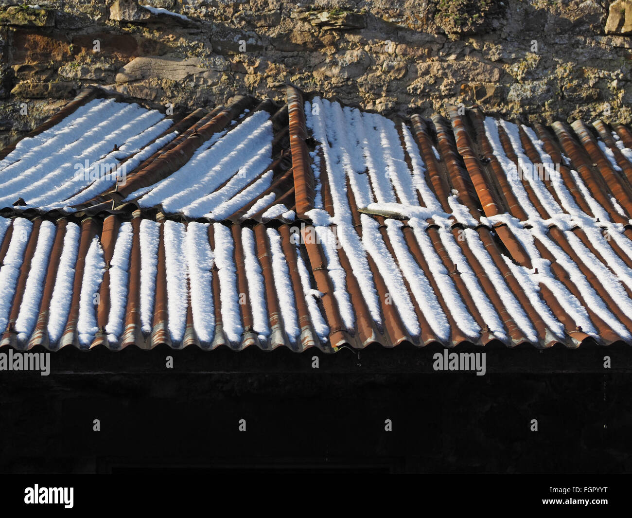 Vieille tôle ondulée sur le toit du bâtiment de ferme en pierres avec la  neige en creux rouillé Photo Stock - Alamy