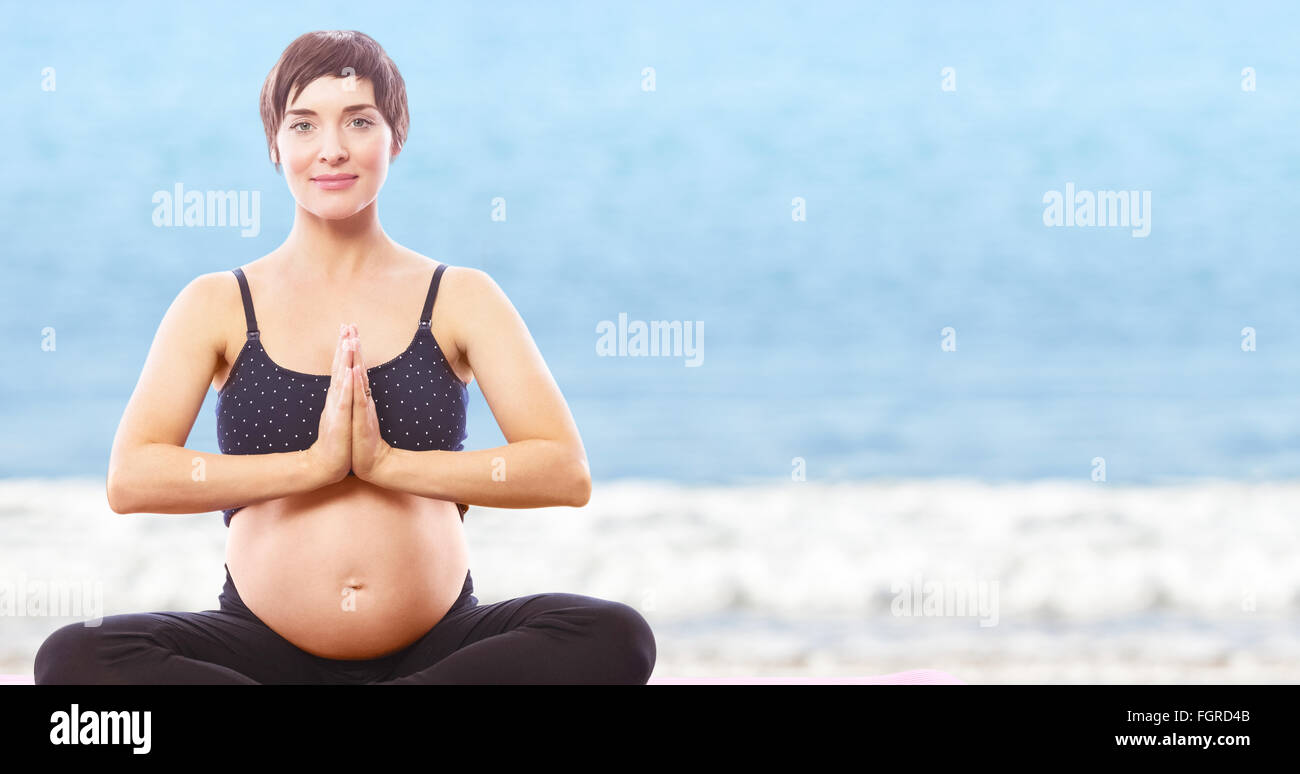 Image composite de portrait happy pregnant woman sitting on exercise mat les mains jointes Banque D'Images