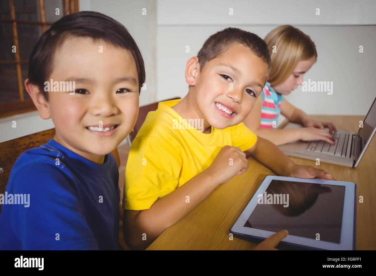 Les élèves en classe à l'aide de Mignon et tablette pour ordinateur portable Banque D'Images