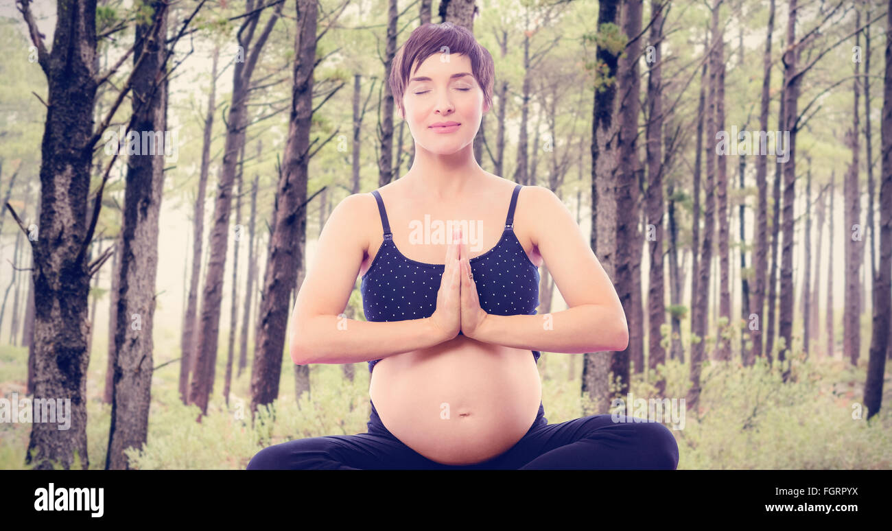 Image composite de pregnant woman sitting on exercise mat les mains jointes Banque D'Images