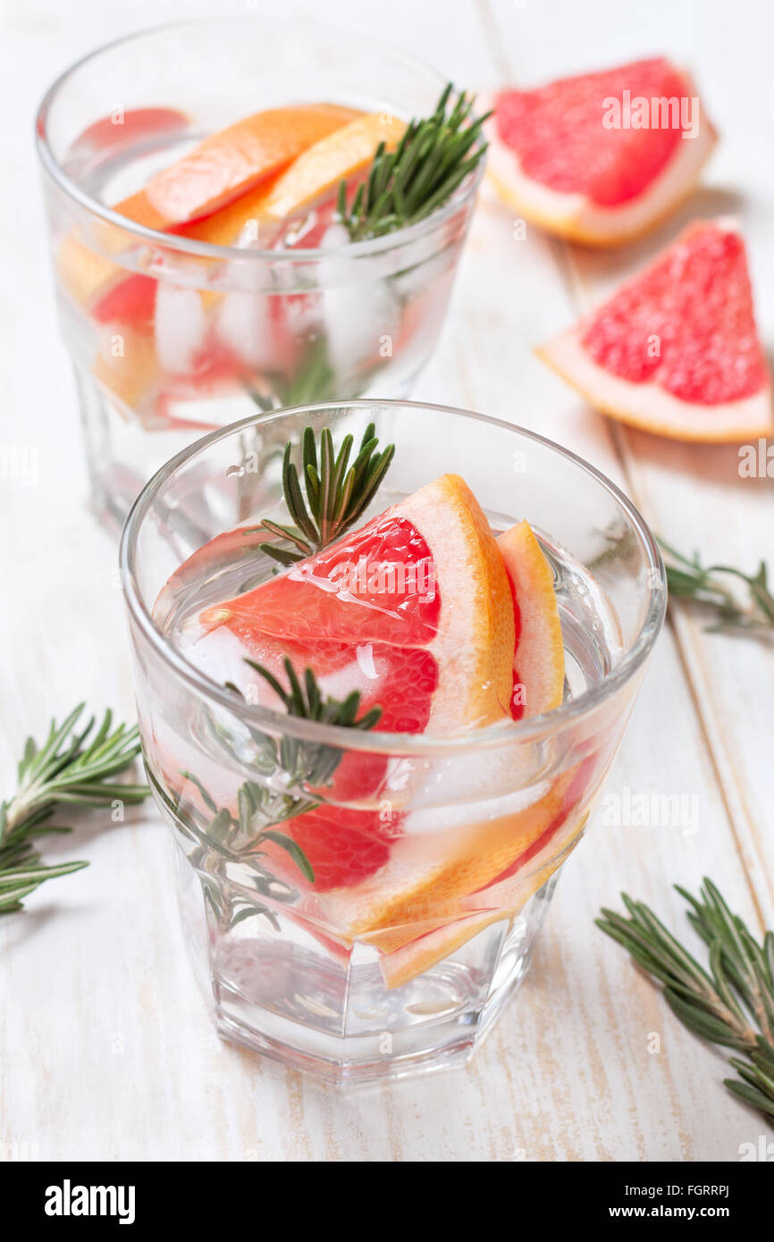 L'eau avec du pamplemousse et de désintoxication de Rosemary, la glace dans les verres sur un fond de bois blanc Banque D'Images