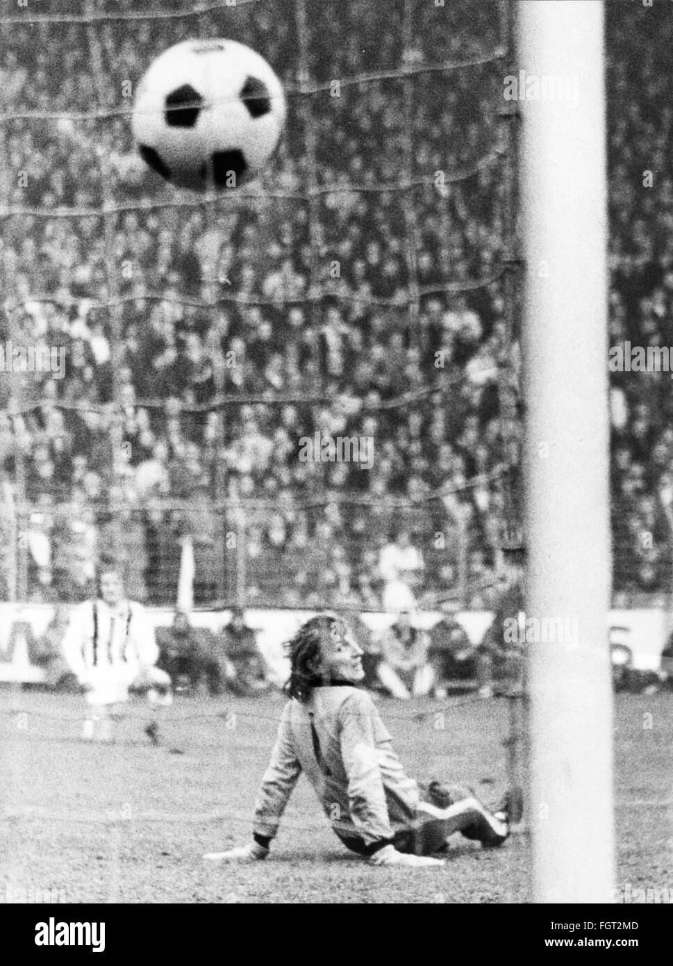 Hommes des années 1970 jouant au football Banque d'images noir et blanc