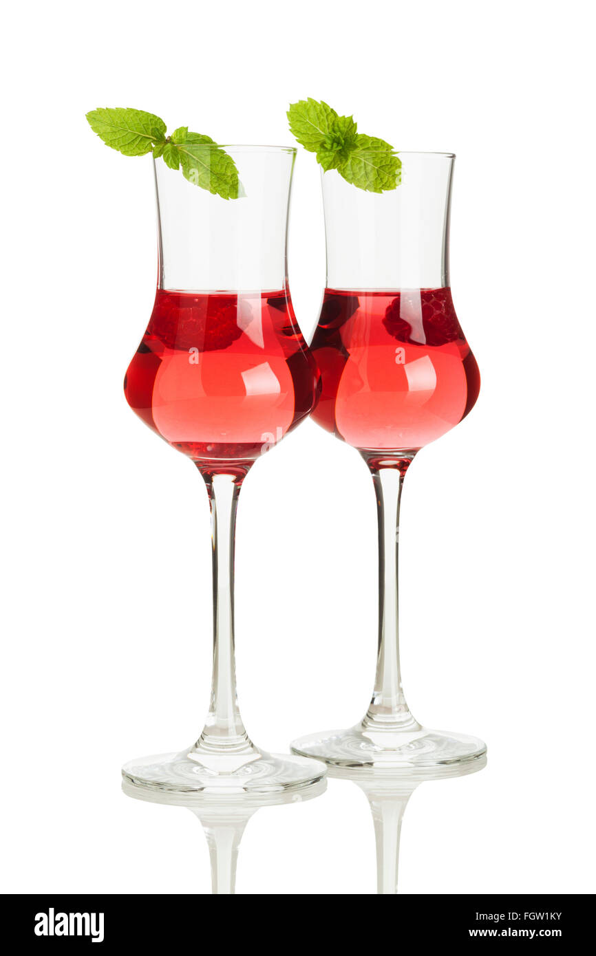 Deux verres de liqueur de framboise décorée de feuilles de menthe isolé sur fond blanc Banque D'Images