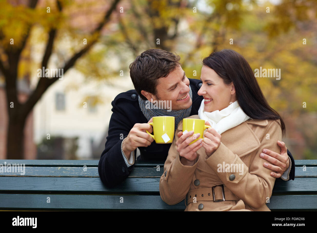 Couple heureux de boire le thé dans un parc d'automne Banque D'Images