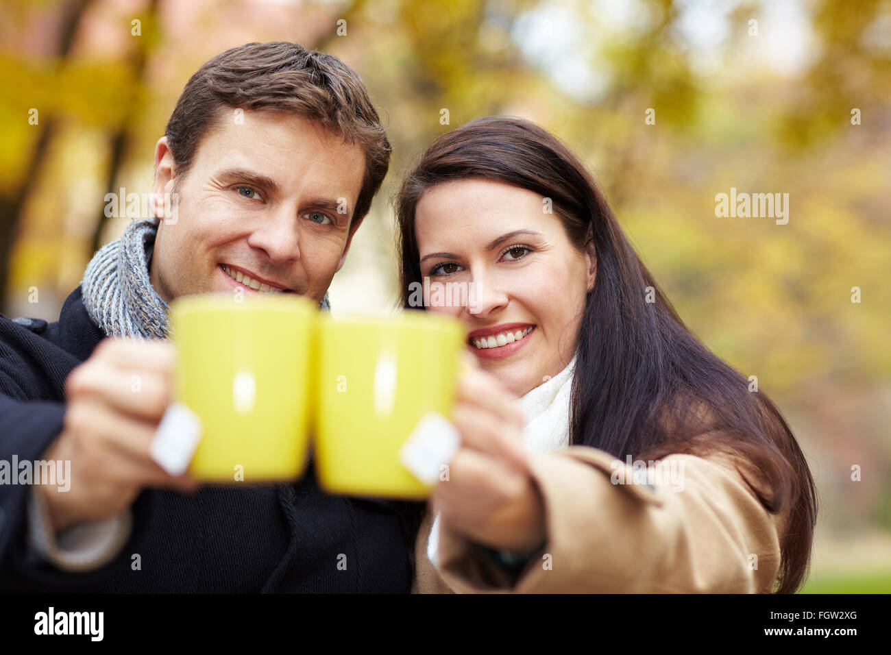 Couple heureux dans un parc d'automne avec grillage plateau Banque D'Images