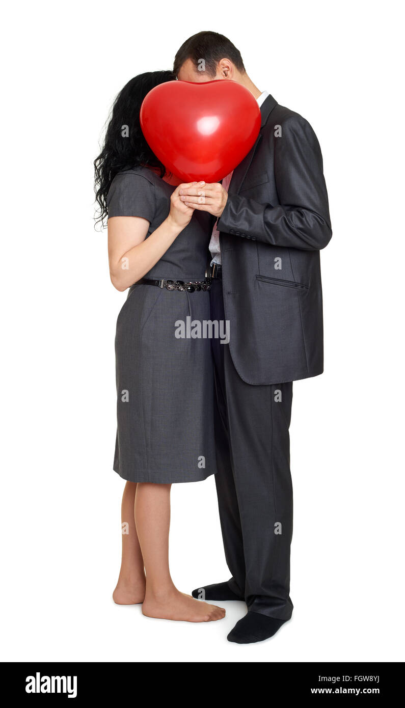 Heureux couple s'embrasser et se cacher derrière un ballon en forme de coeur rouge. Maison de vacances Valentine concept. Studio isolated Banque D'Images