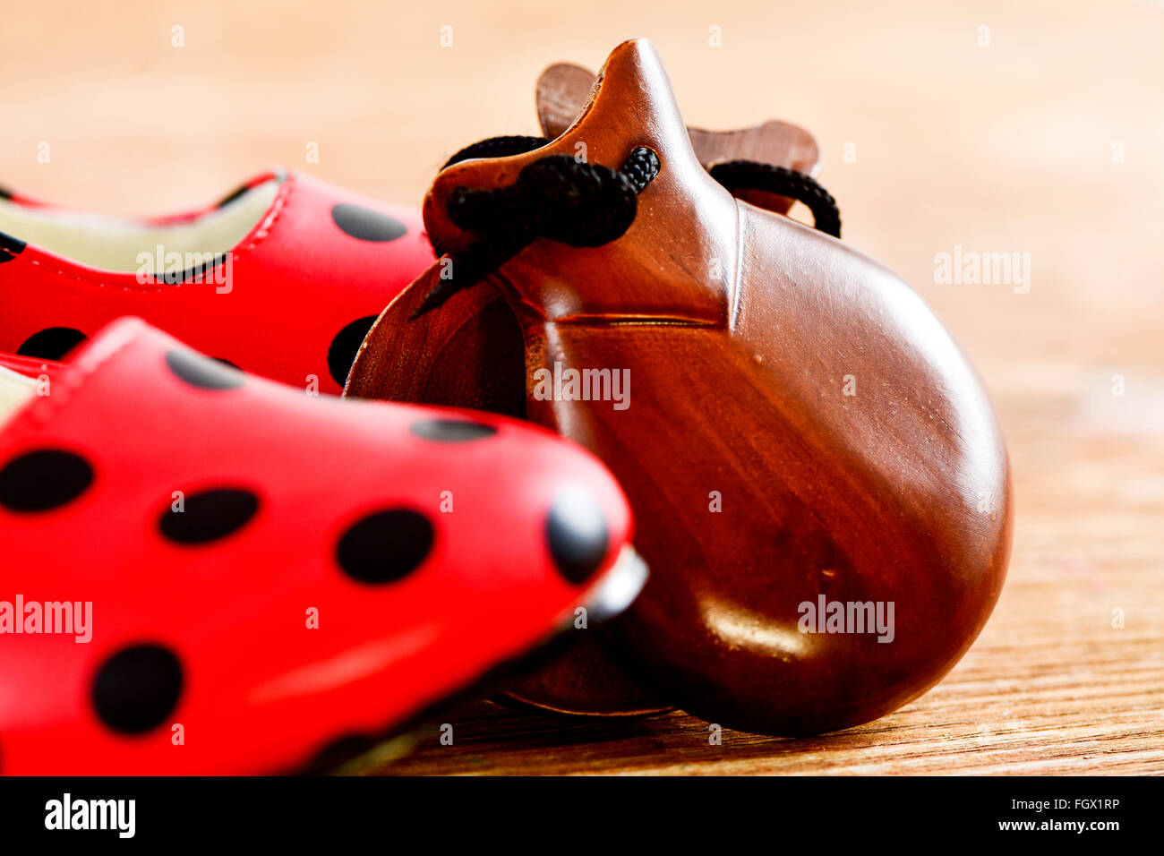 Libre d'une paire de castagnettes et une paire de point-typique rouge à motifs chaussures flamenco, sur une surface en bois Banque D'Images