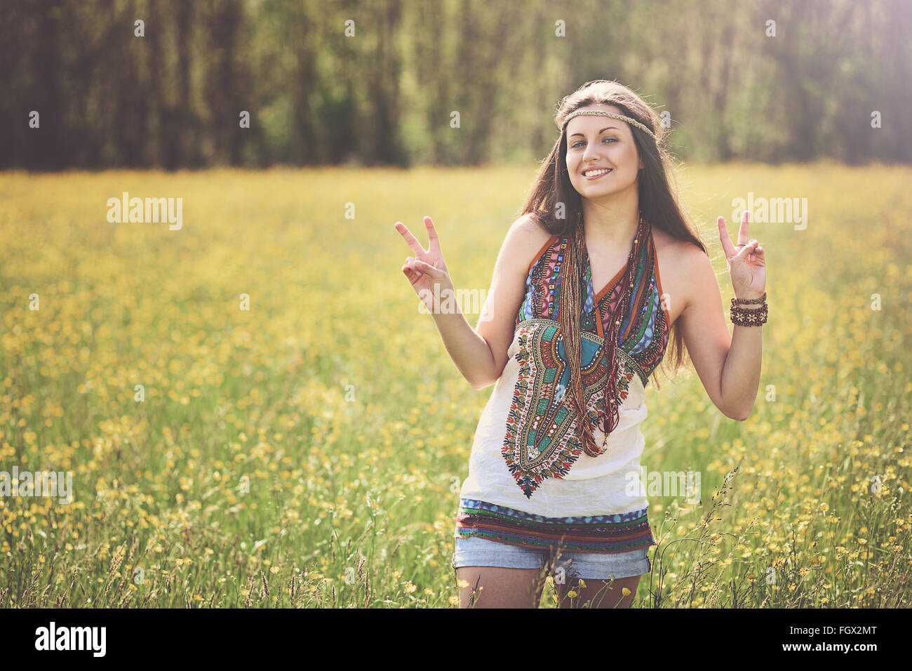 Signe de Paix de hippie souriant dans un pré. La liberté et l'harmonie Banque D'Images