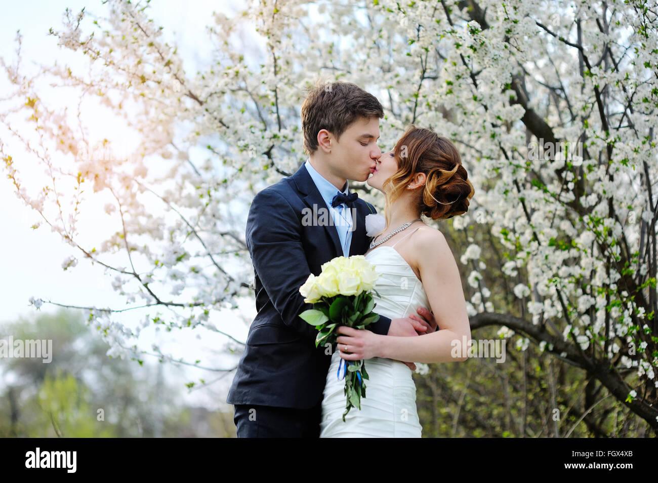 Mariée et le marié avec un bouquet de marcher dans le parc d'été Banque D'Images