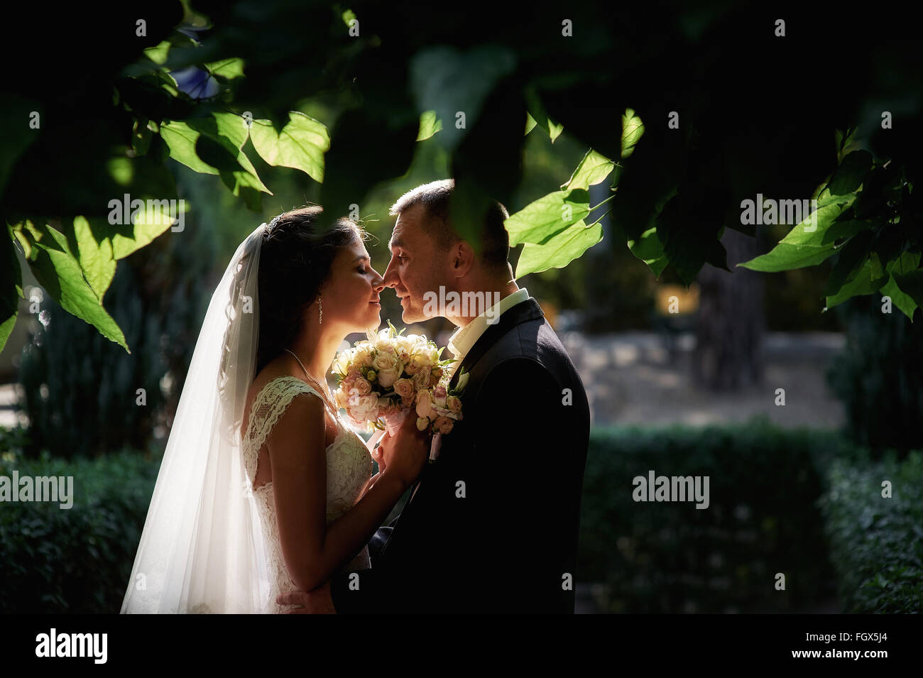 Mariée et le marié avec un bouquet de marcher dans le parc d'été Banque D'Images