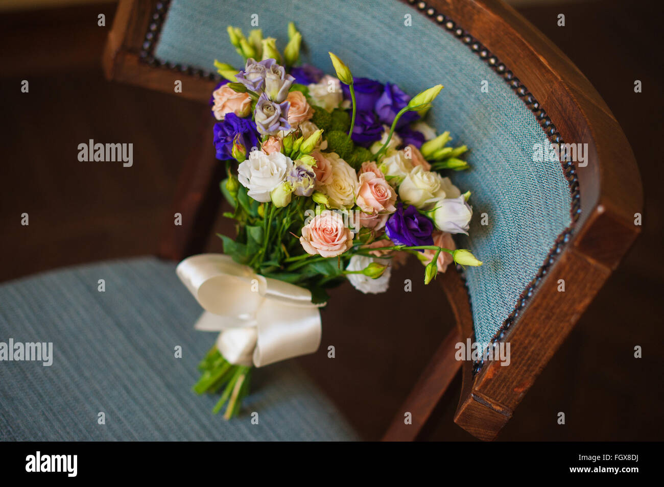 Rose et violet fleurs en bouquet de mariée mariage sur une chaise Banque D'Images