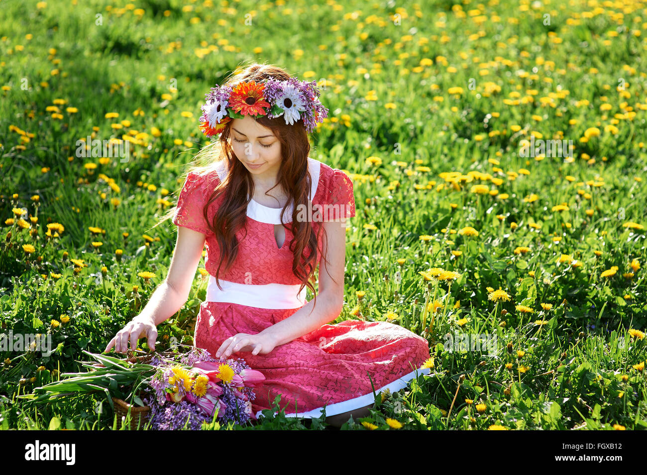 Belle femme avec une couronne assis sur l'herbe dans un pré Banque D'Images