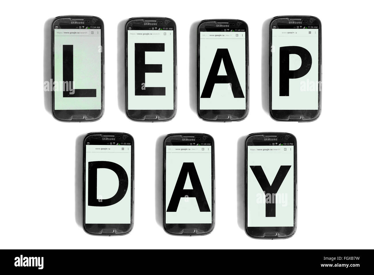 Leap Day écrit sur les écrans de smartphones photographié sur un fond blanc. Banque D'Images