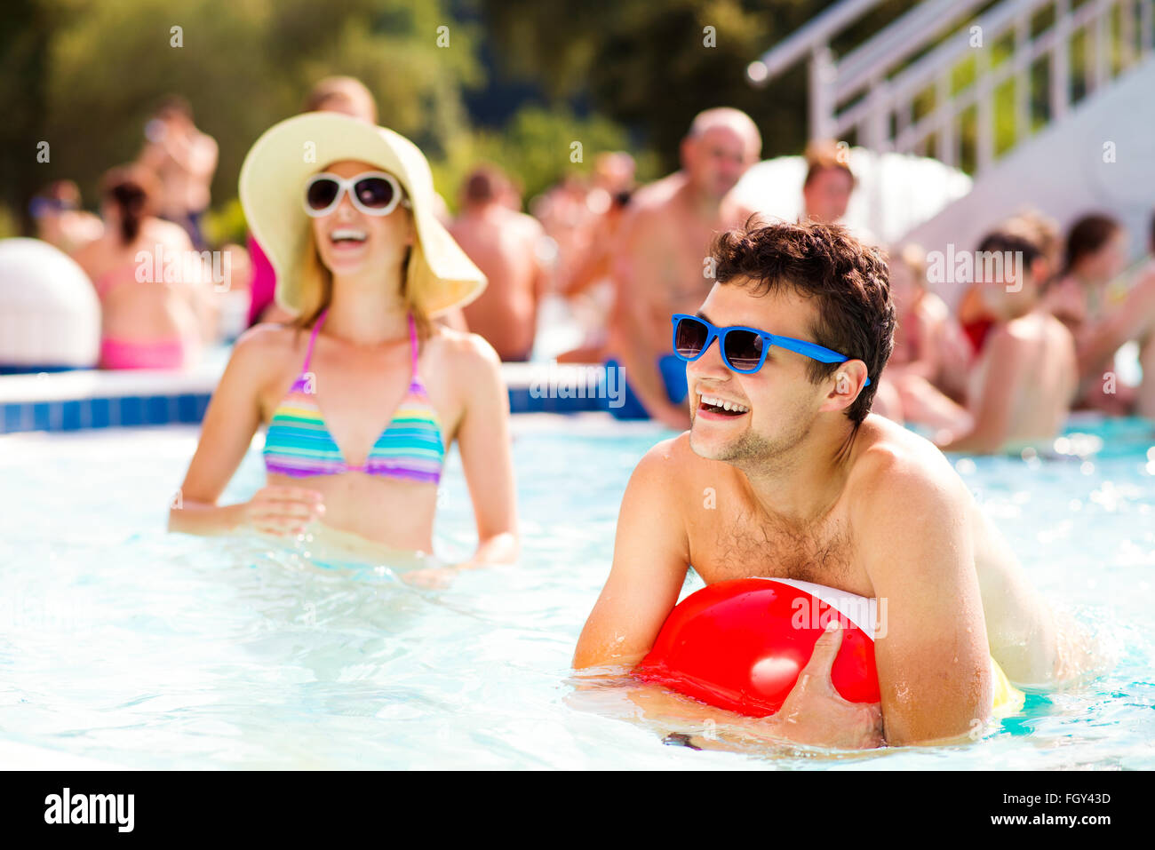 Couple avec des lunettes de soleil dans la piscine. L'été et l'eau. Banque D'Images