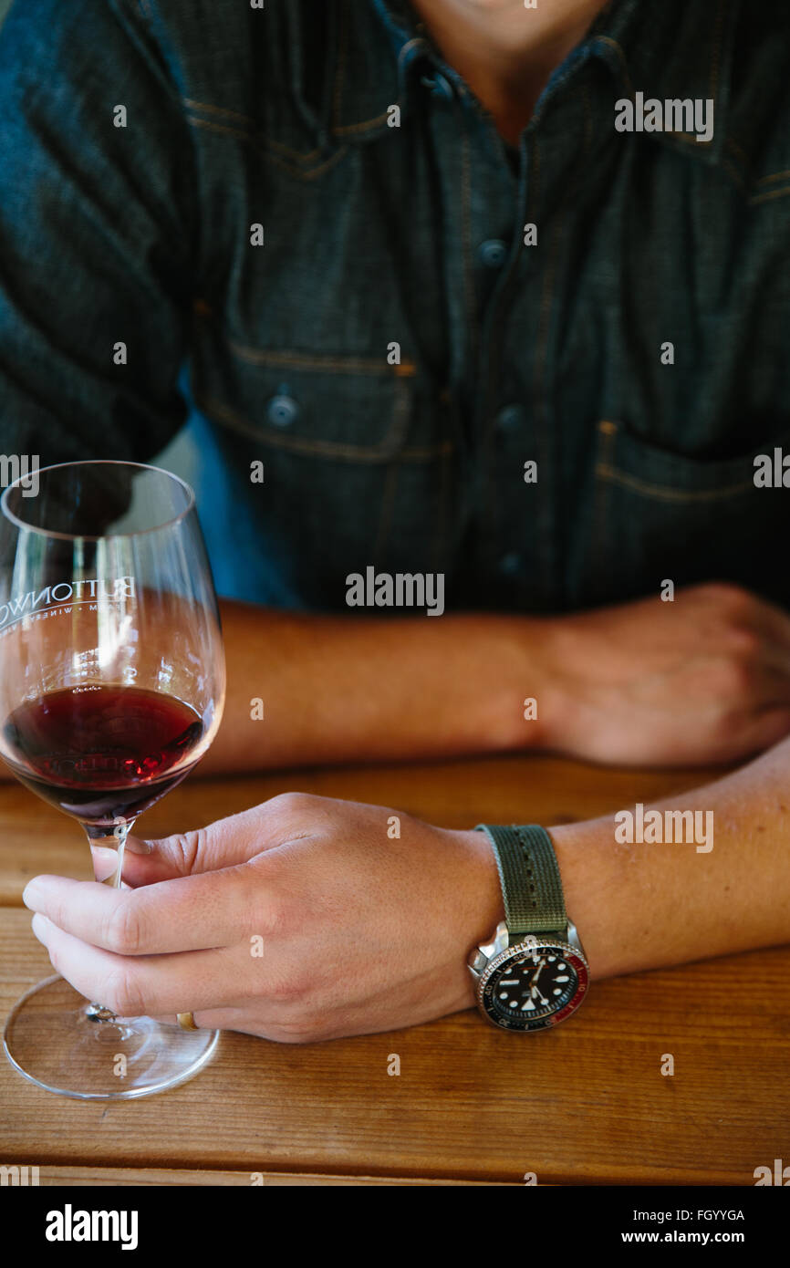 Un jeune homme bénéficie d'un verre de vin à Santa Ynez, en Californie. Banque D'Images