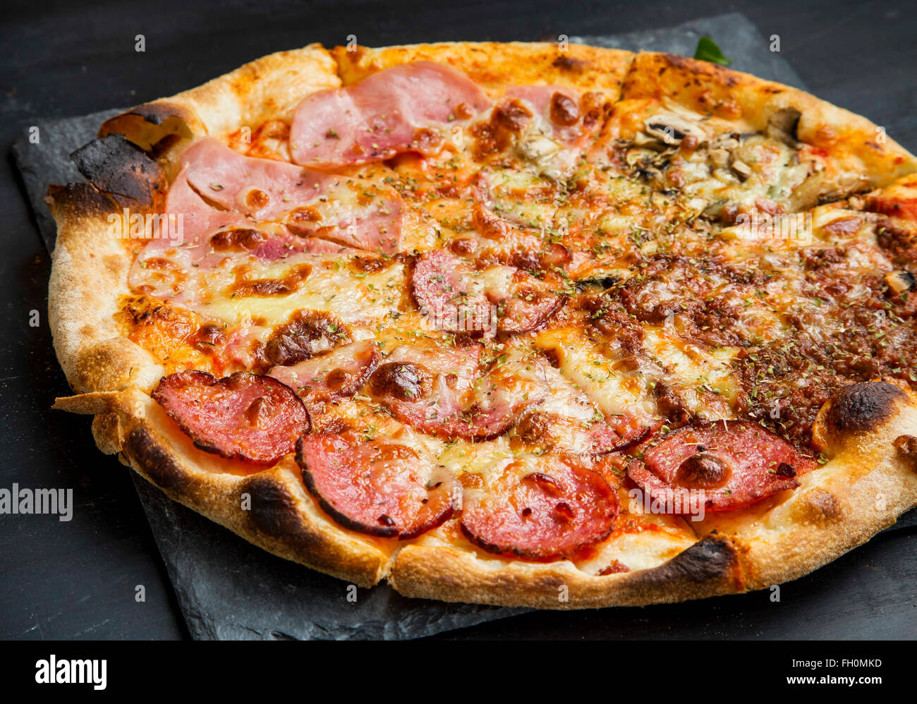 Pizza quatro stagione au salami,jambon, poulet et viande hachée