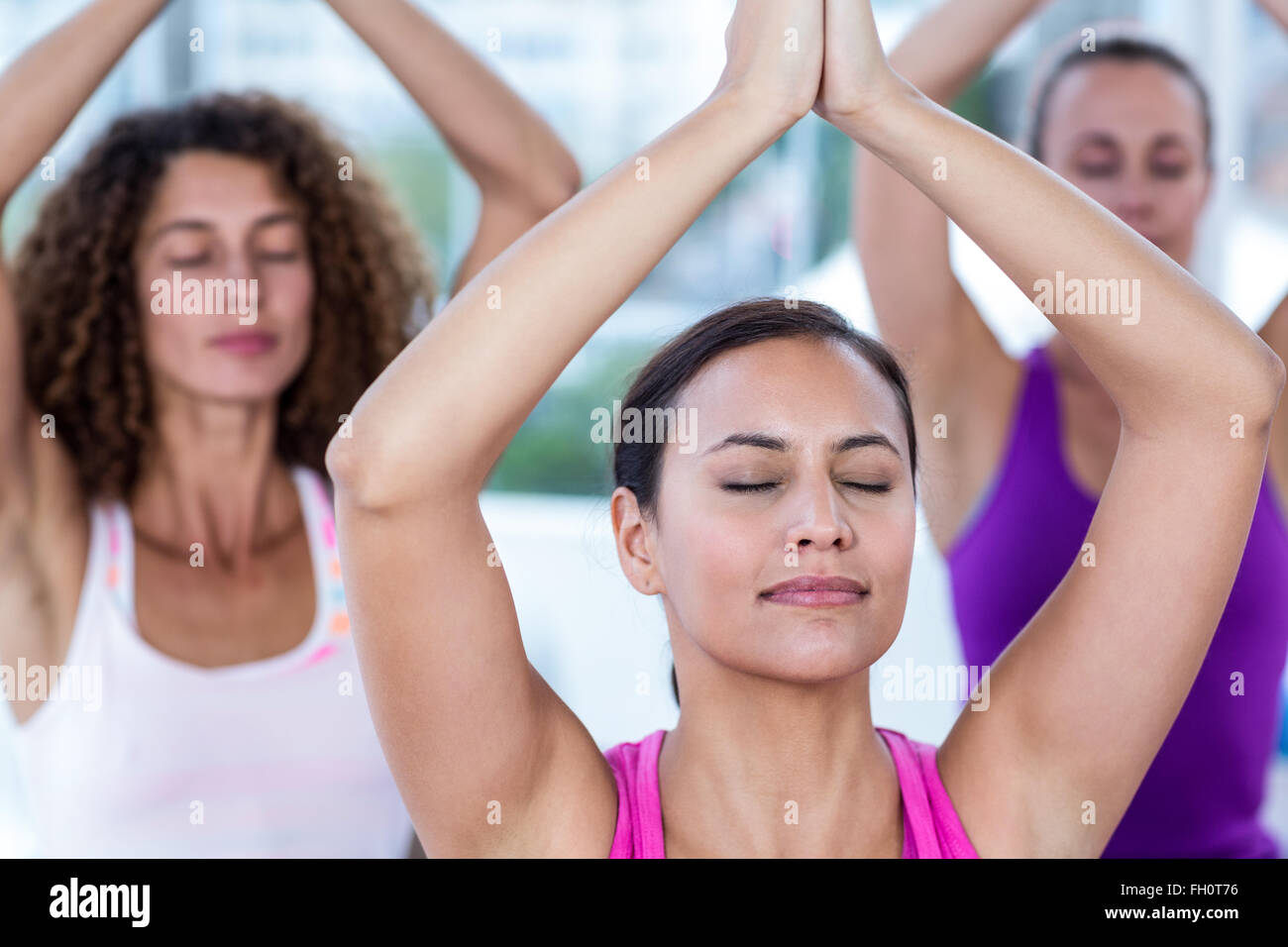 Les femmes méditant avec mains jointes et bras levés Banque D'Images