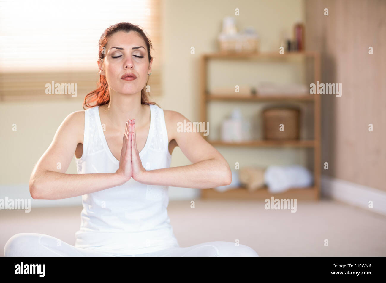 Femme méditant avec mains jointes Banque D'Images