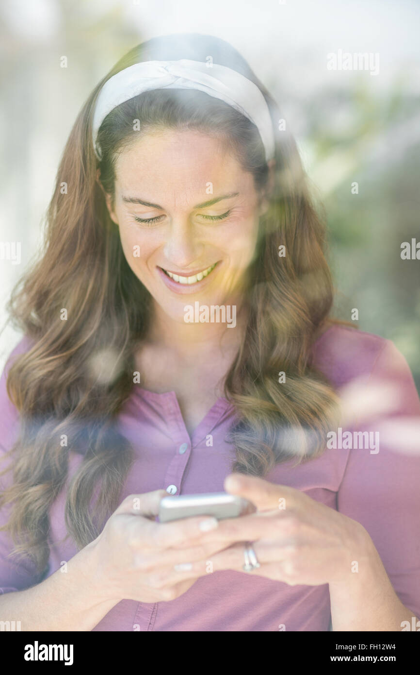 Happy woman text messaging on mobile Banque D'Images