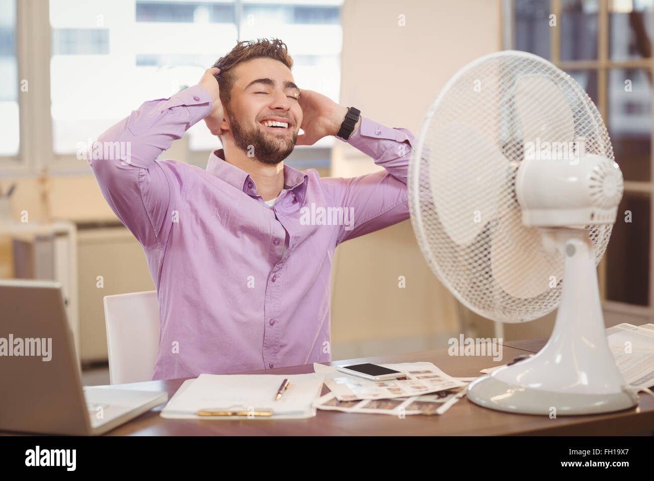 Relax man par ventilateur électrique Banque D'Images