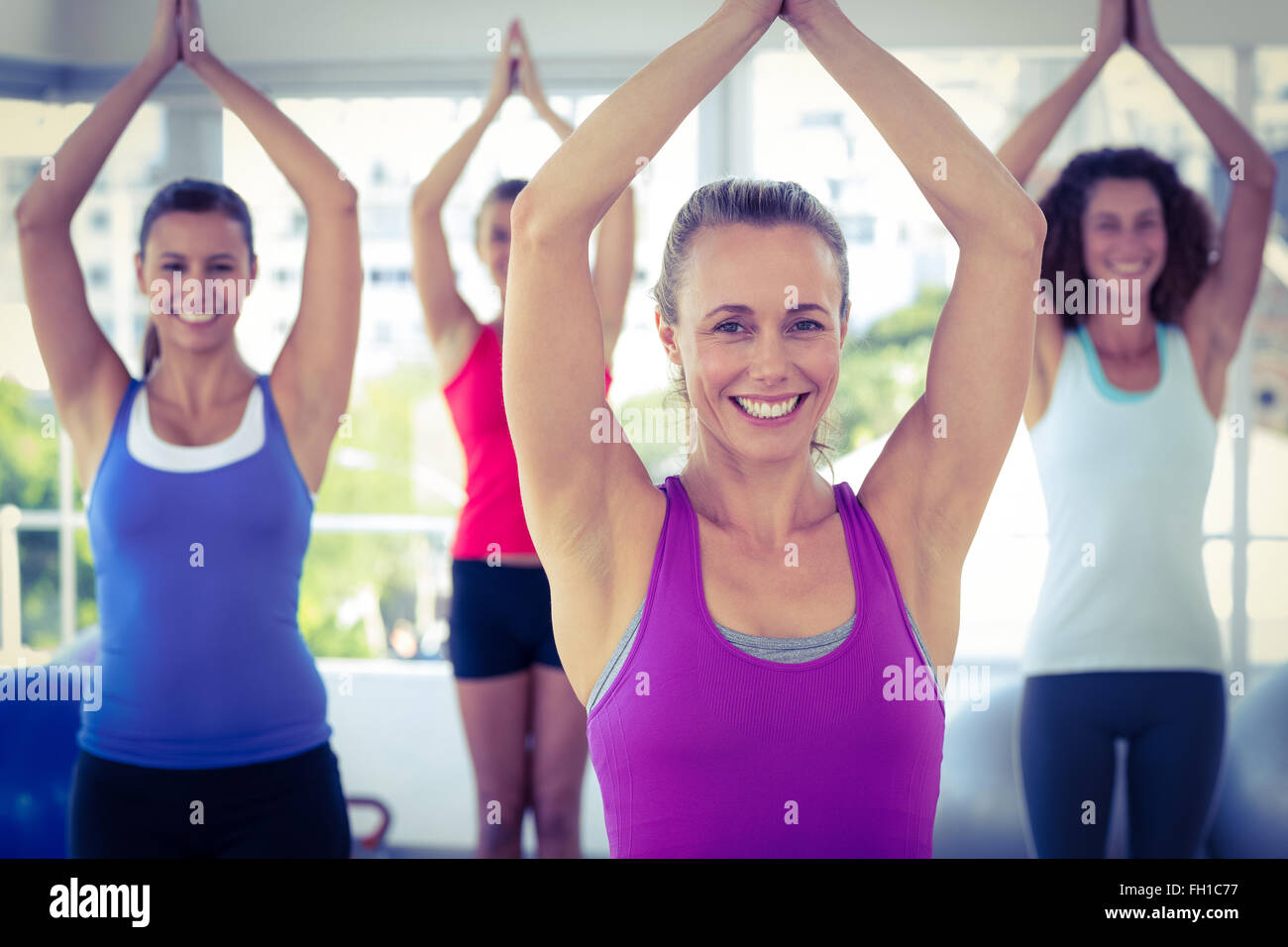 Cheerful women in fitness studio les mains jointes Banque D'Images