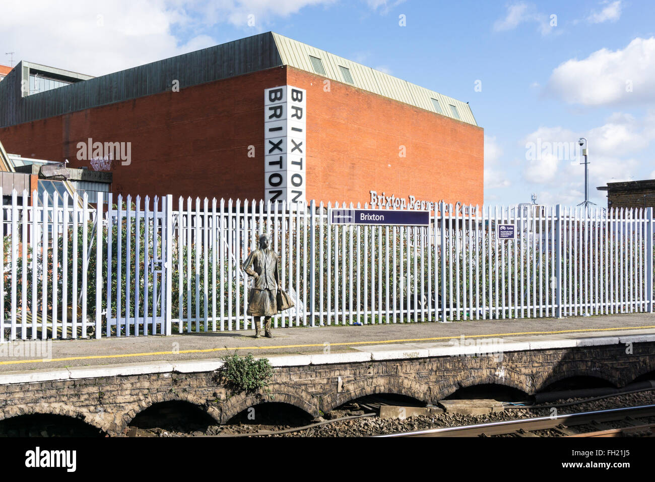 Statue de passagers en attente sur la station de Brixton. Pièce plate-formes par Kevin Atherton, 1986. Brixton Recreation Centre en arrière-plan Banque D'Images