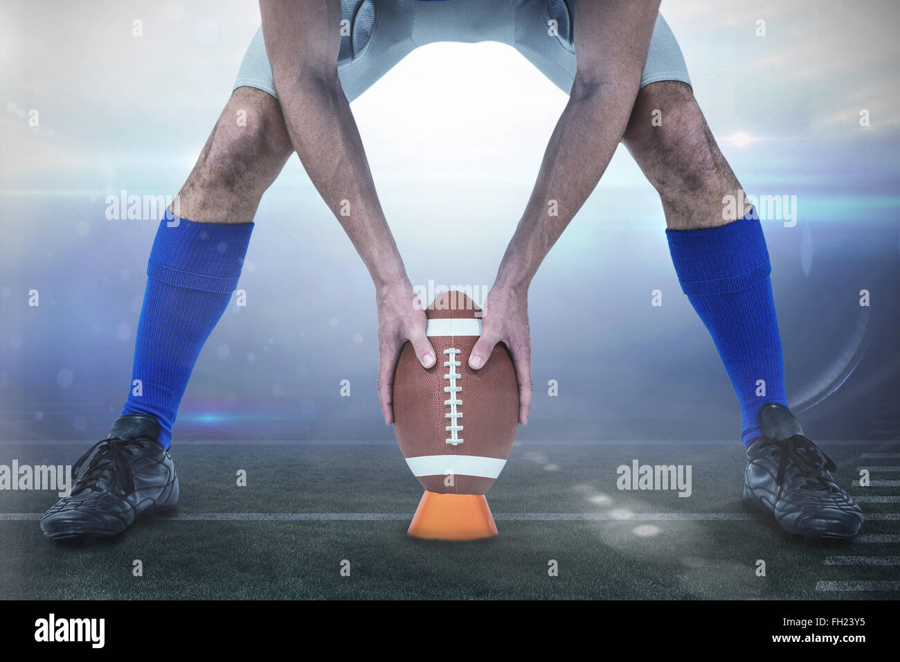 Image composite du football américain joueur plaçant ballon entre les jambes Banque D'Images