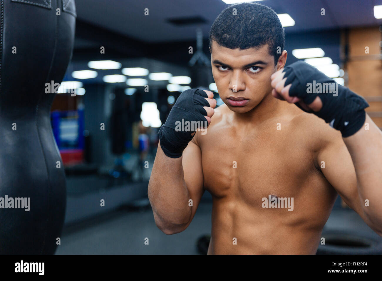 Beau mâle boxer entraînement avec sac de boxe Banque D'Images
