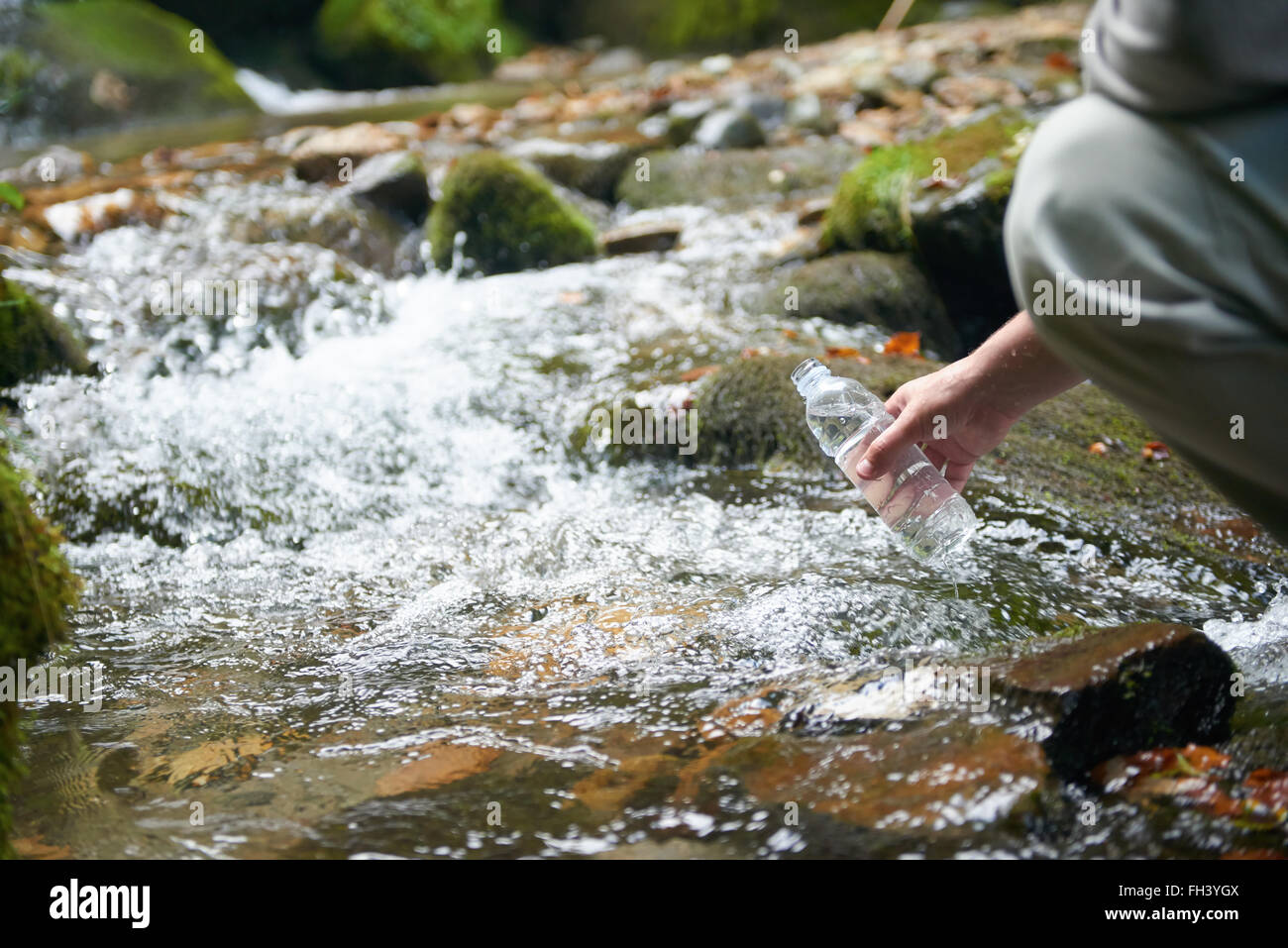 L'homme de boire l'eau fraîche de printemps Banque D'Images