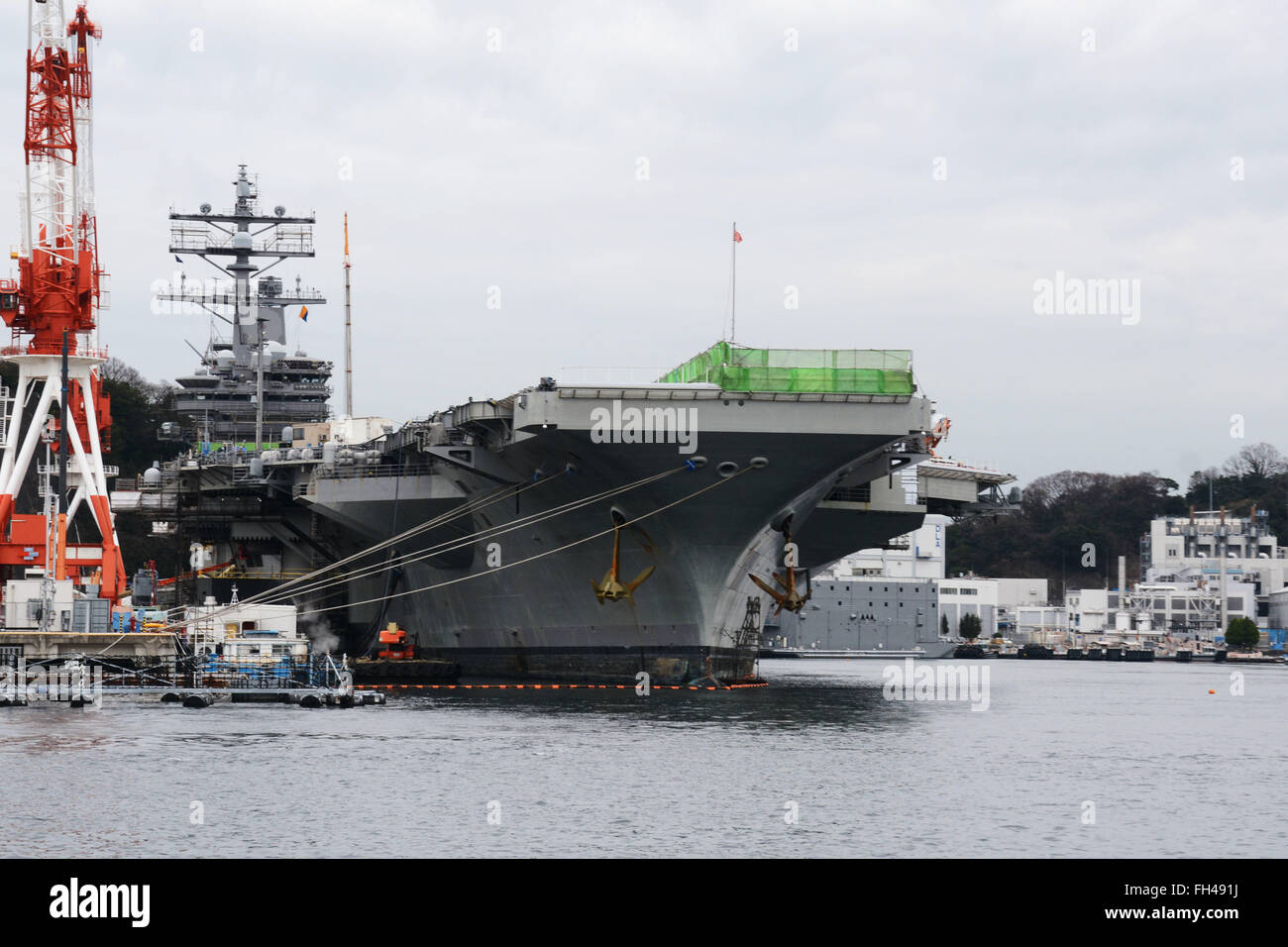 YOKOSUKA, Japon (fév. 22, 2016) La Marine américaine est que l'avant-déployé, porte-avions USS Ronald Reagan (CVN 76), est assis à côté de la jetée (FLEACT) du parc automobile de Yokosuka. FLEACT fournit de Yokosuka, entretient et exploite des installations et des services de base à l'appui de la 7e flotte des forces navales déployées, 83 commandes et 24 000 locataires, le personnel militaire et civil. Banque D'Images