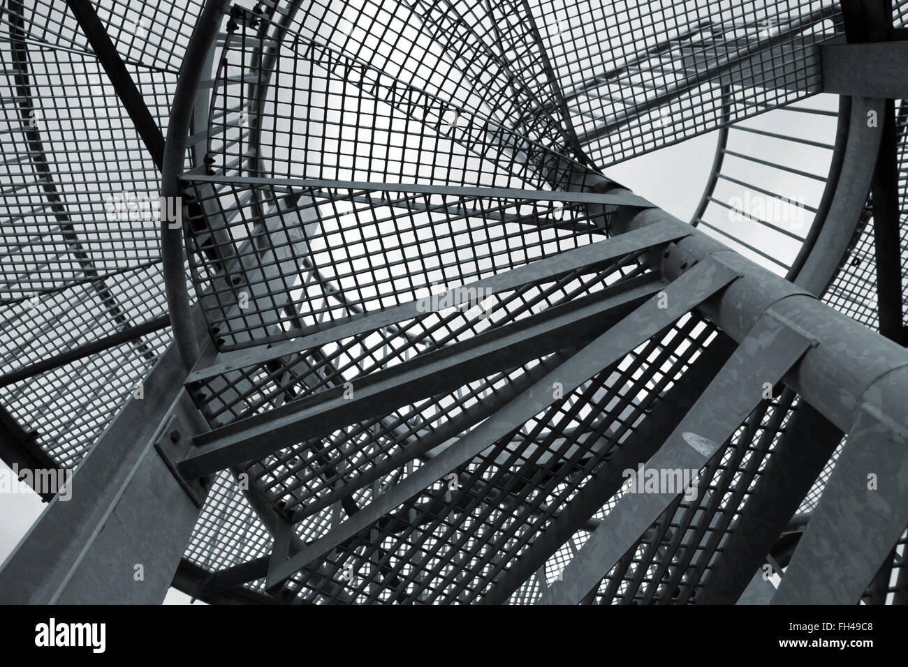 Résumé Contexte industriel en acier avec échelle en spirale, fragment de photo dans les tons bleus Banque D'Images