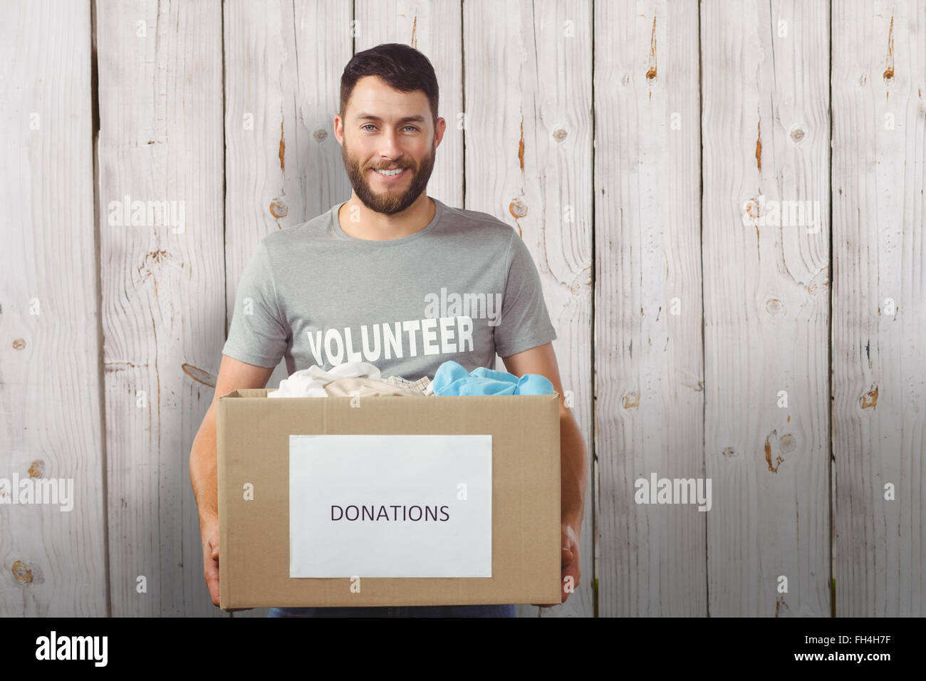 Image composite de portrait of man holding clothes donation box in office Banque D'Images
