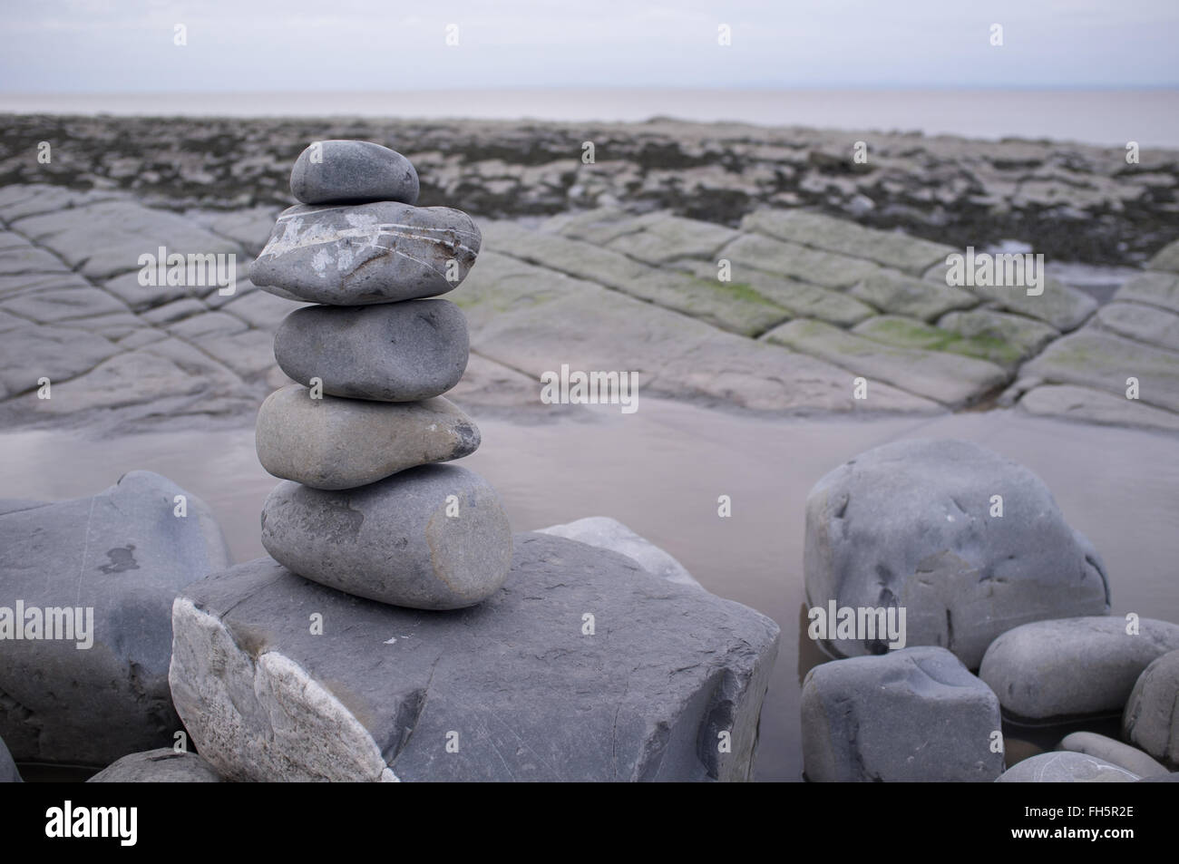 Un cairn de galets sur une plage de rochers Banque D'Images