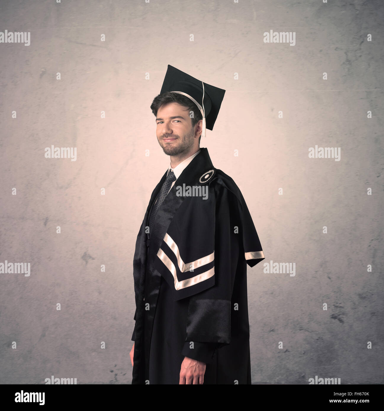Portrait d'un jeune étudiant diplômé sur fond grunge Banque D'Images