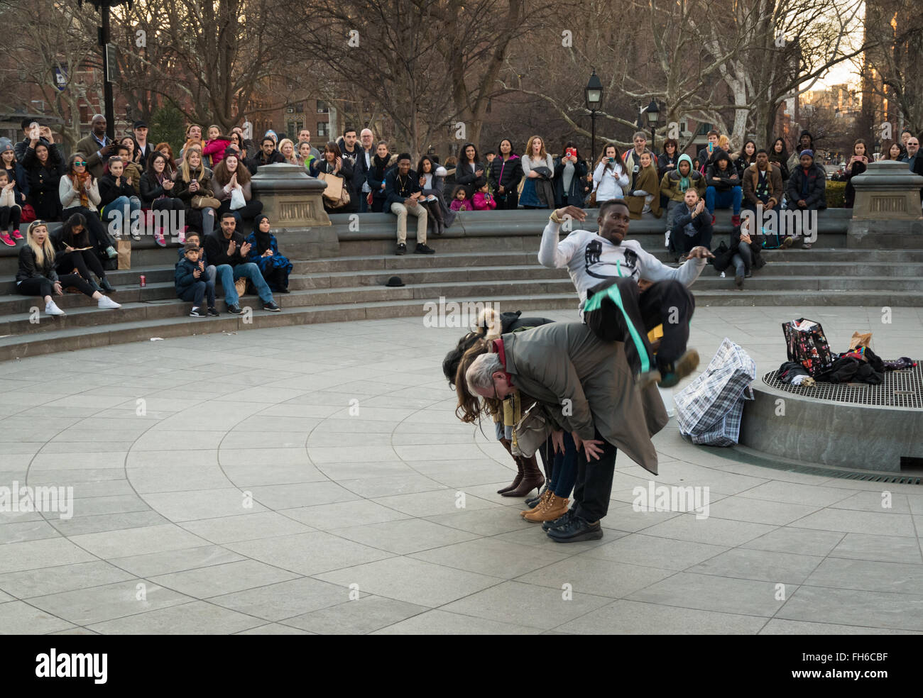 Performance de rue à Washington Square Park d'acrobat somersaulting plus de bénévoles avec des foules de spectateurs Banque D'Images