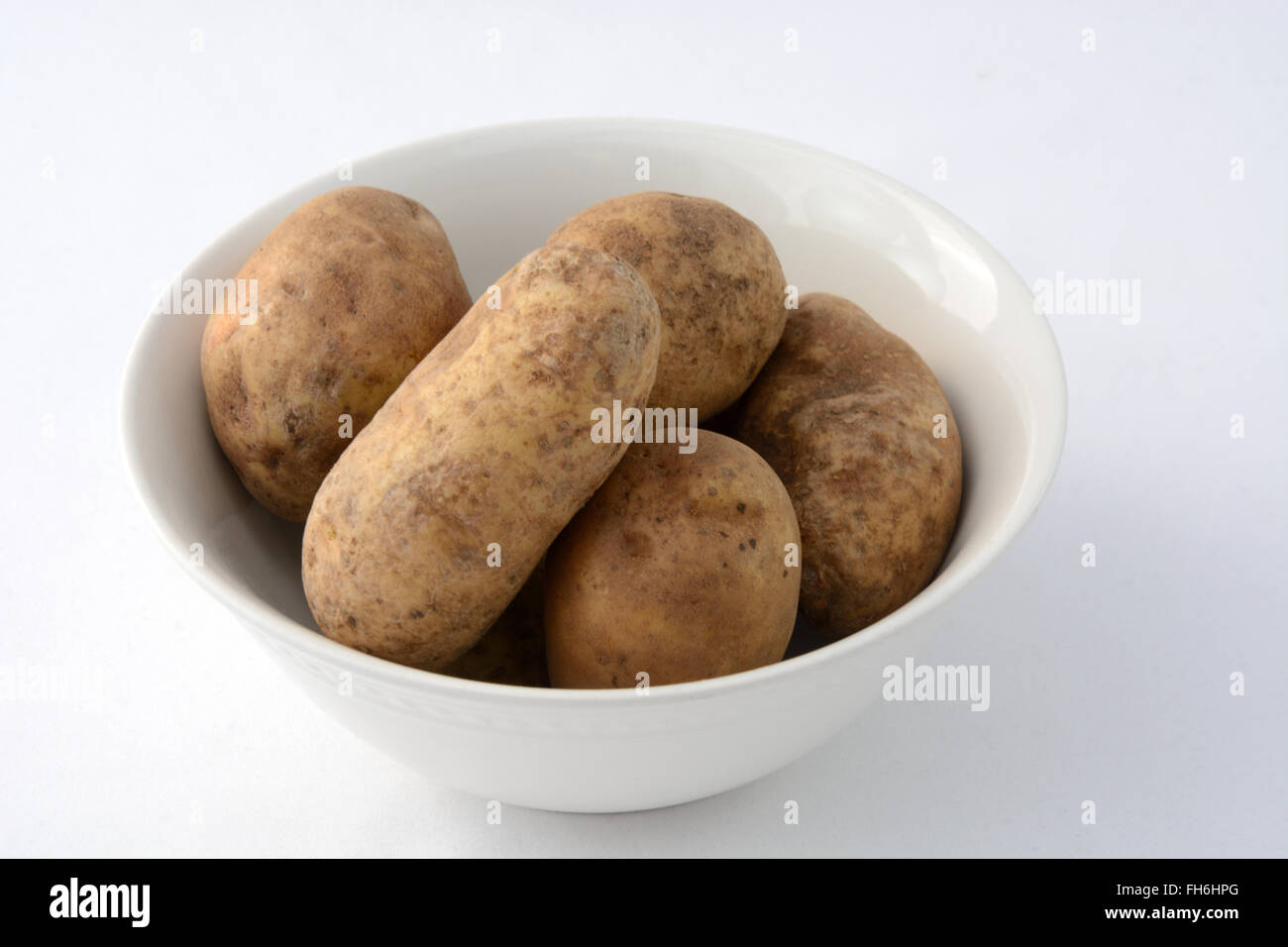 Les pommes de terre roussâtres en white bowl Banque D'Images