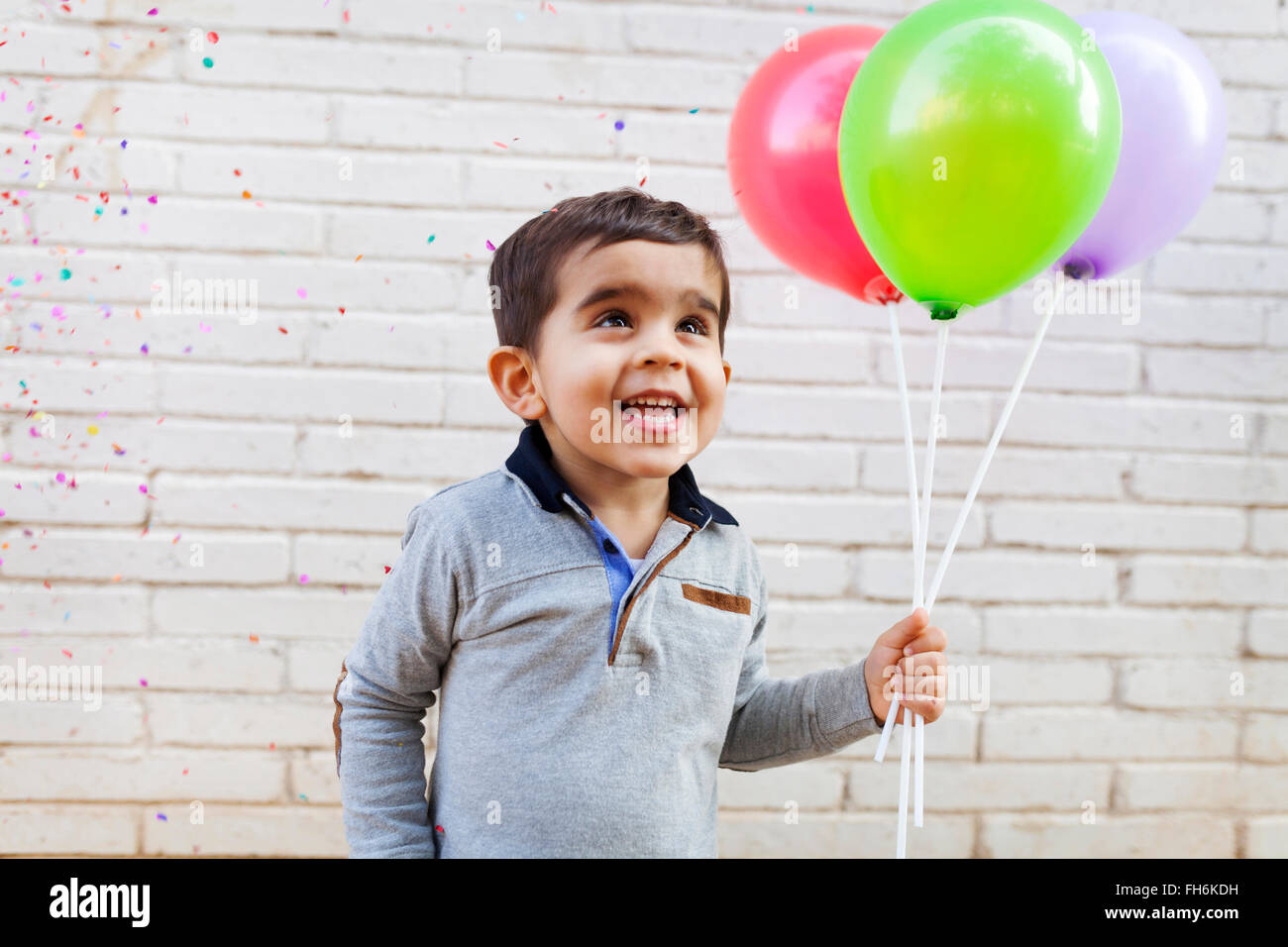 Portrait of happy toddler holding trois ballons Banque D'Images