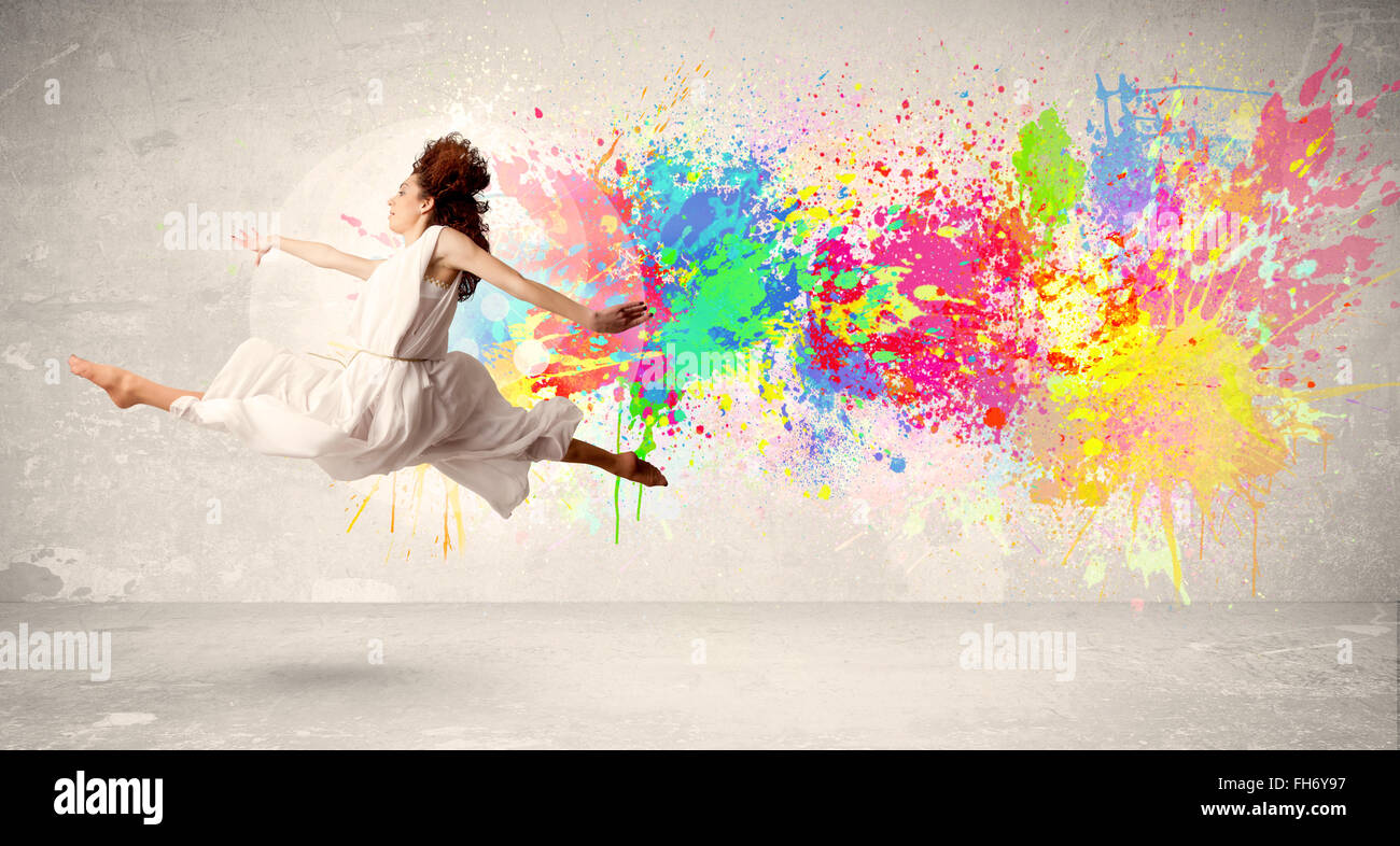 Happy teenager jumping avec de l'encre couleur de fond urbain éclabousser Banque D'Images