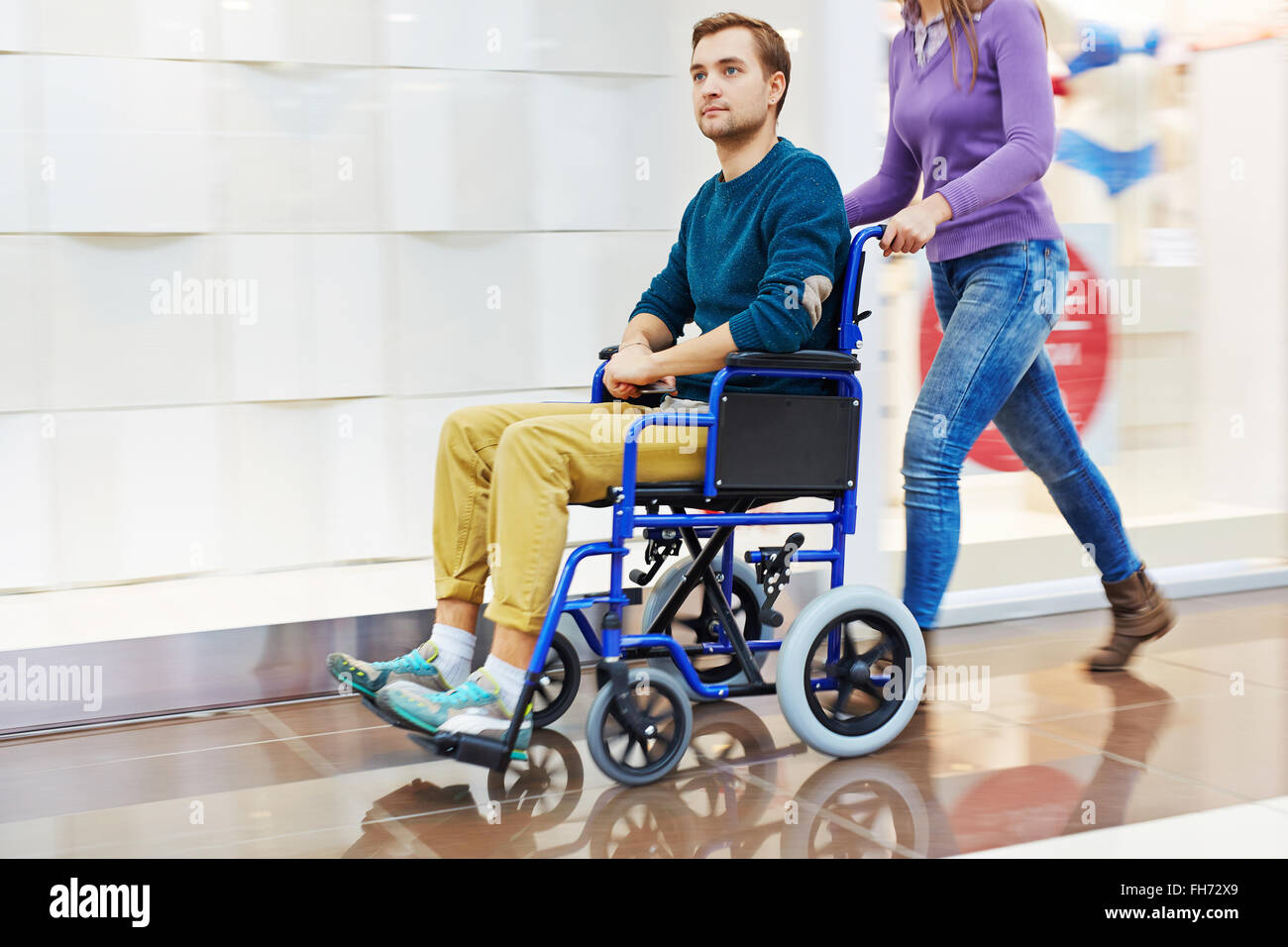Guy en fauteuil roulant d'être déplacé par son aide-soignant Photo Stock -  Alamy
