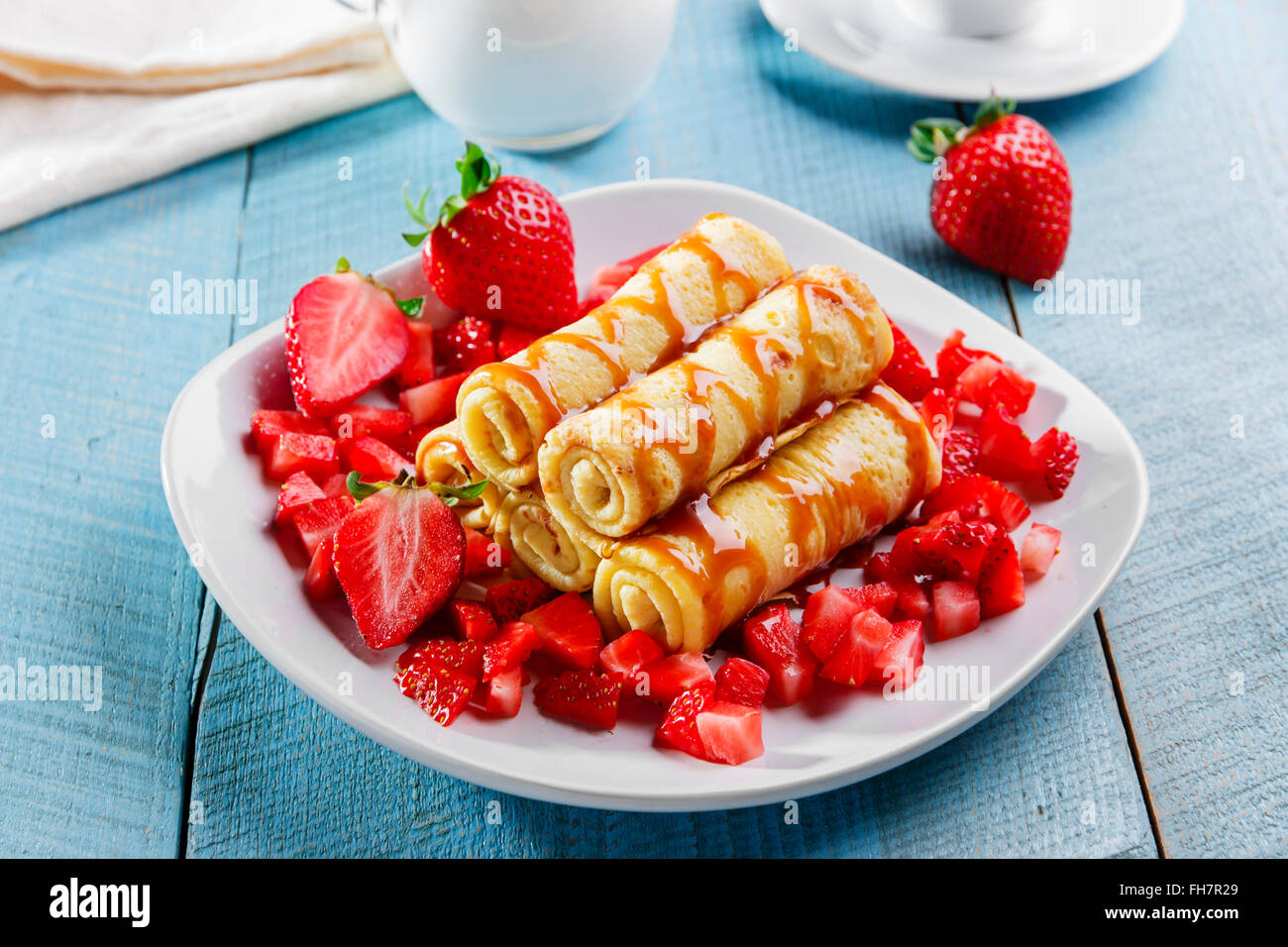 Crêpes roulées avec fraises et petit-déjeuner au caramel Banque D'Images