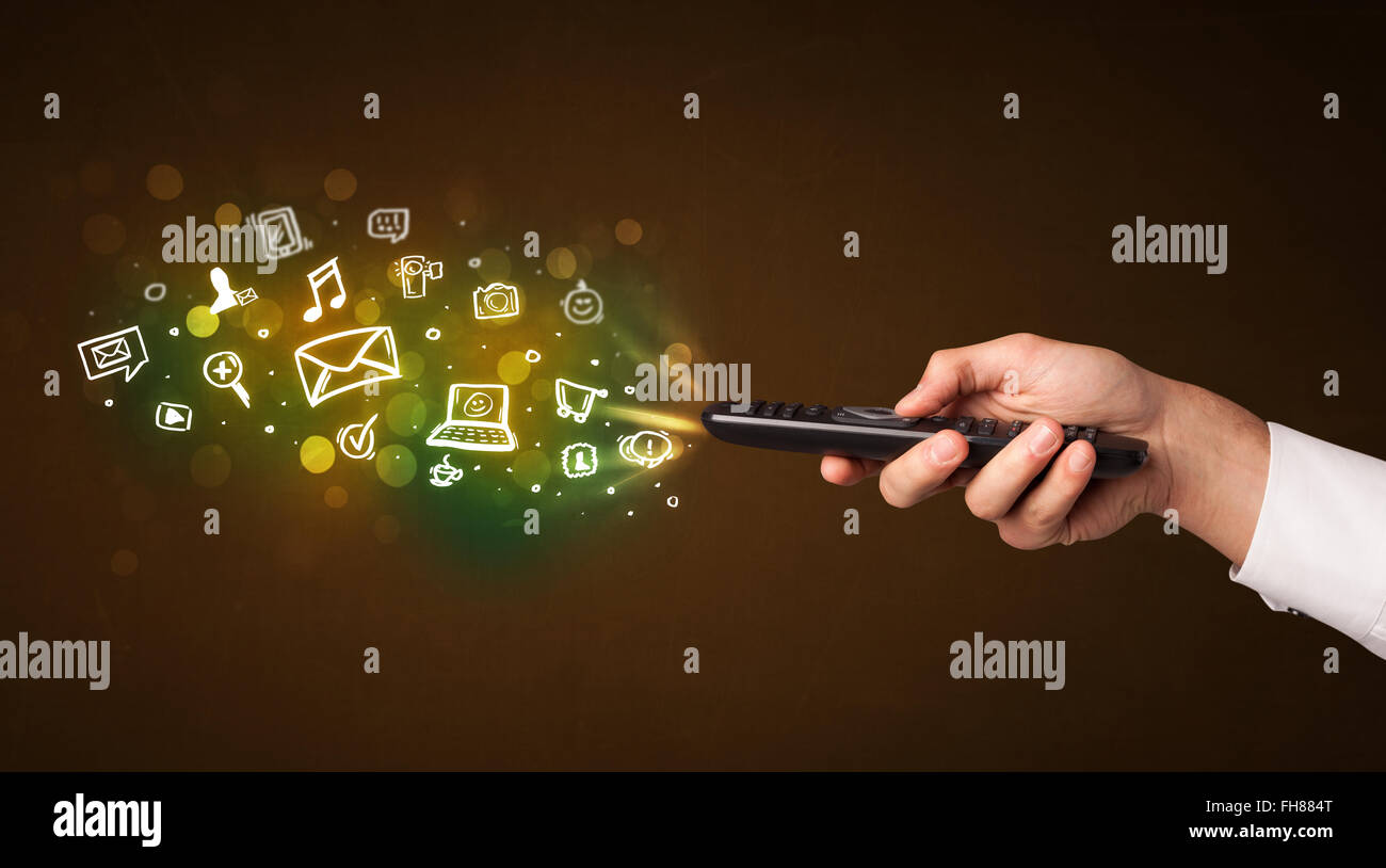 La main avec télécommande et icônes de médias sociaux Banque D'Images
