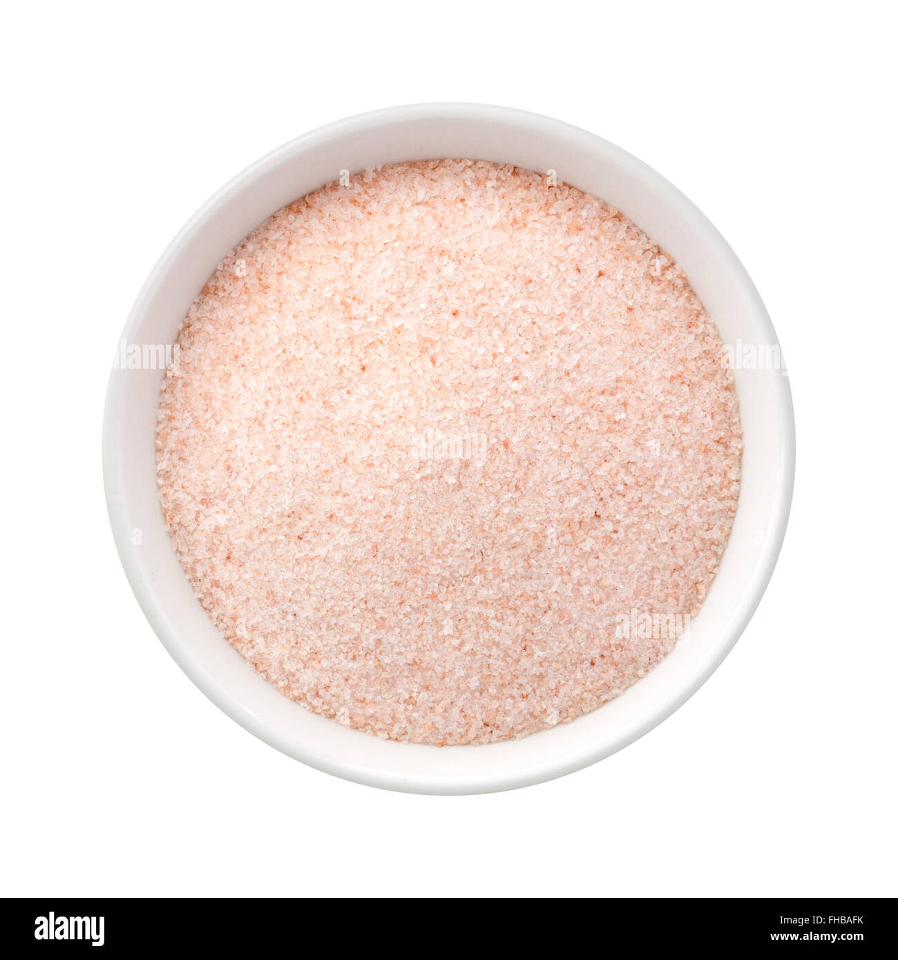 Fine sel rose de l'Himalaya dans un bol en céramique. L'image est un coupé, isolé sur un fond blanc. Banque D'Images