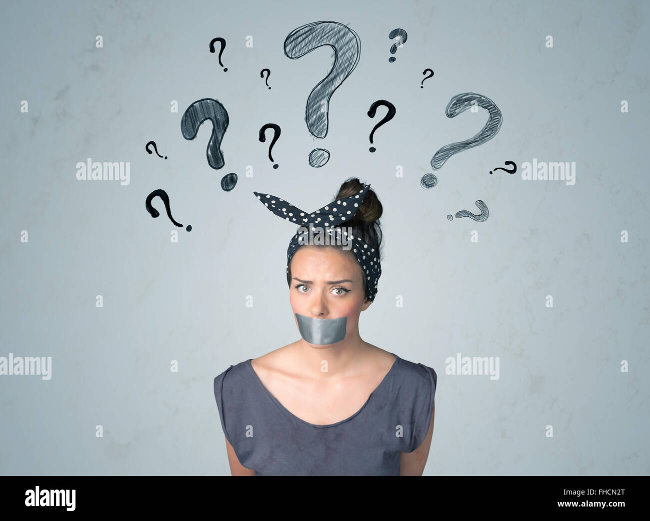 Jeune femme avec la bouche collée et symboles d'interrogation Banque D'Images