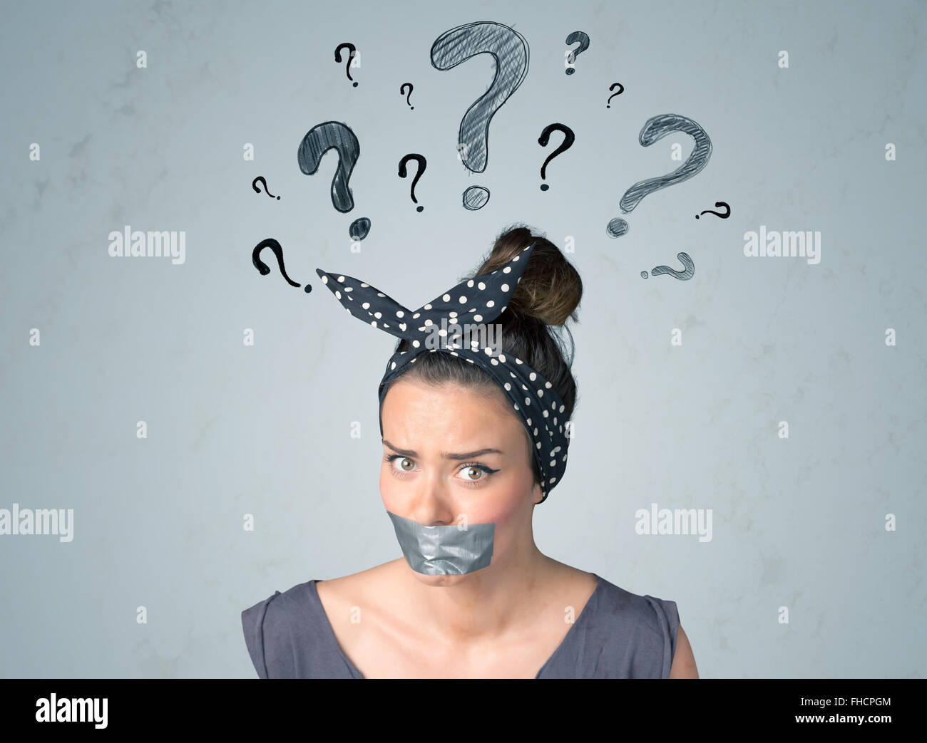 Jeune femme avec la bouche collée et symboles d'interrogation Banque D'Images