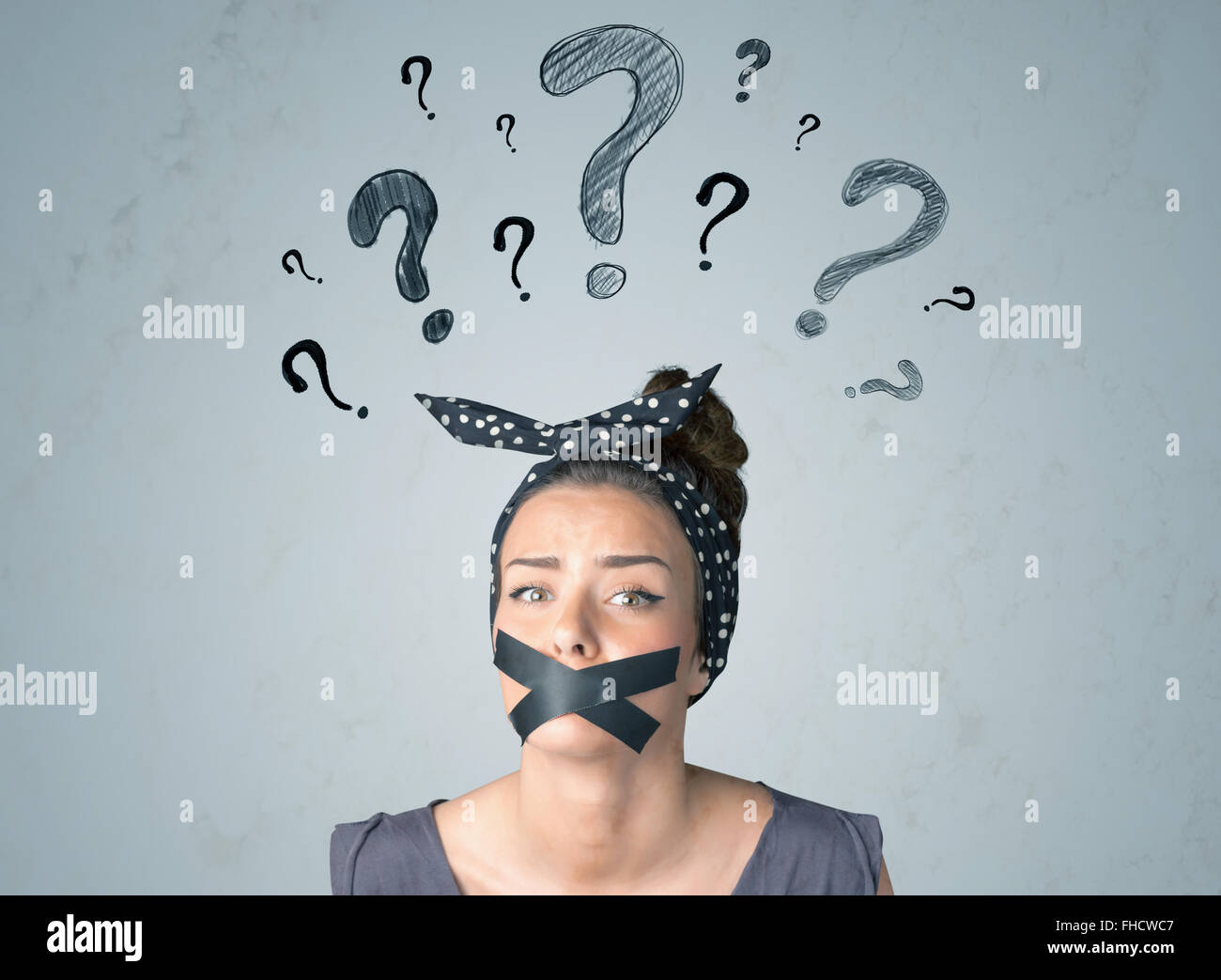 Jeune femme avec la bouche collée et symboles d'interrogation Banque D'Images