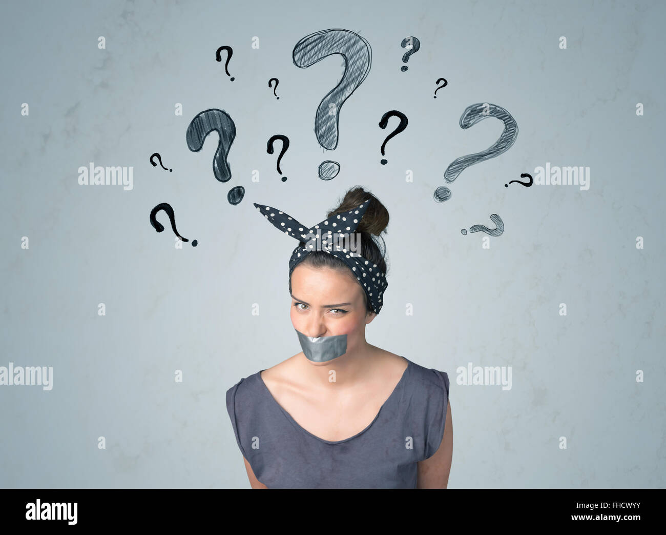 Jeune femme avec la bouche collée et symboles d'interrogation Banque D'Images