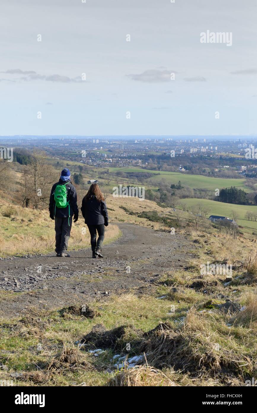Un jeune couple en train de marcher dans le vieux Kilpatrick hills surplombant Glasgow, Écosse, Royaume-Uni, sur une belle journée hivers. Banque D'Images